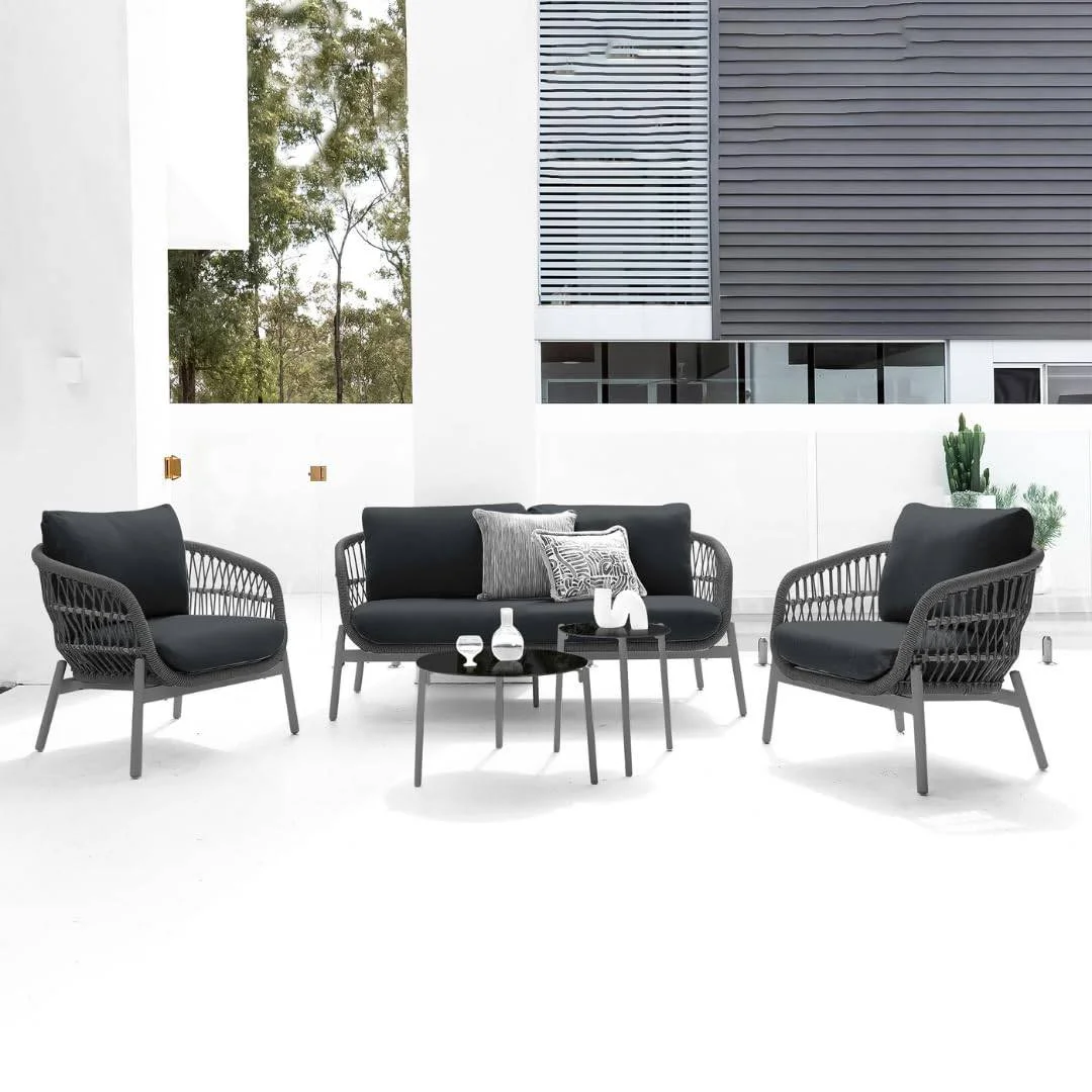 Outdoor garden 4-seater rope sofa with light grey cushions and dark grey woven rope frame placed on a patio.