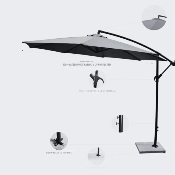 Off-white 9 ft outdoor cantilever patio umbrella with marble base and crank handle in a garden setting.