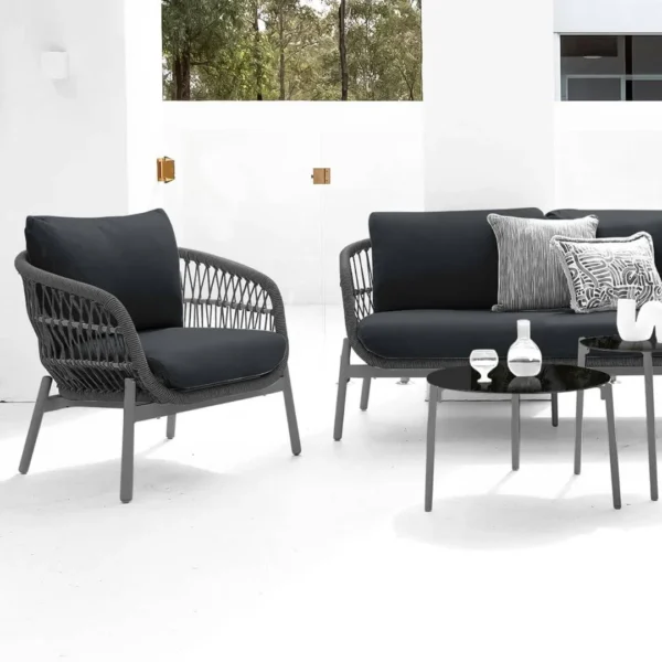 Outdoor garden 4-seater rope sofa with light grey cushions and dark grey woven rope frame placed on a patio.