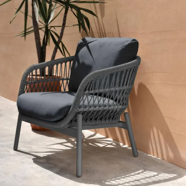 Outdoor garden 4-seater rope sofa with light grey cushions and dark grey woven rope frame placed on a patio.
