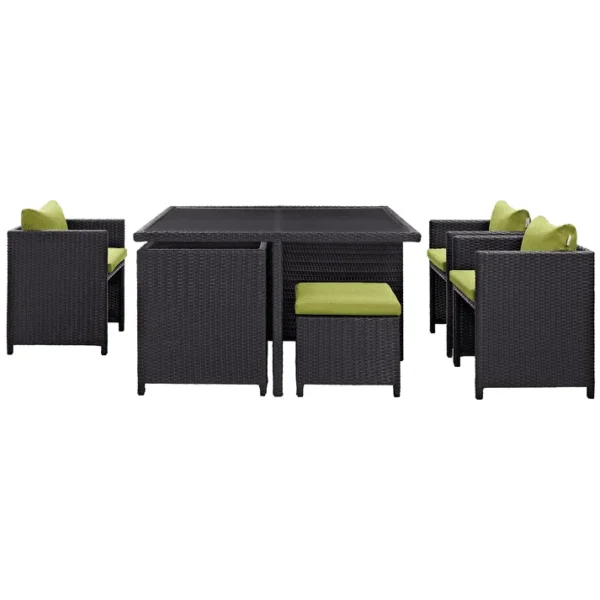 7-piece dark brown wicker outdoor dining set with green cushions, including ottoman and table without glass top