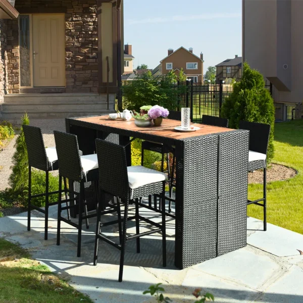 7-piece outdoor rattan bar set in black and off-white with high stools, table, and cushions, perfect for garden or patio settings.