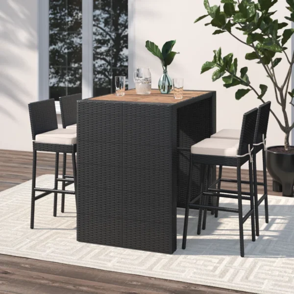 5 piece outdoor patio rattan bar set in black and white with high chairs and a bar table arranged on a garden patio.