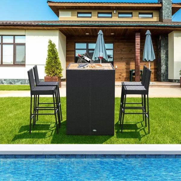5 piece outdoor patio rattan bar set in black and white with high chairs and a bar table arranged on a garden patio.