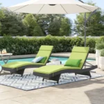 Pair of dark brown and green outdoor patio recliner lounger chairs with all-weather cushions.