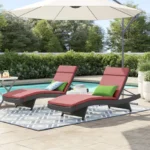 Set of 2 outdoor patio recliner lounger chairs in dark brown with red all-weather cushions.