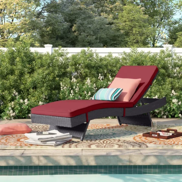 Add a pop of color and comfort to your patio with this stylish dark red wicker chaise lounge chair.