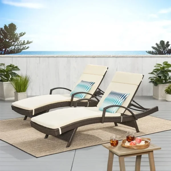 Dark brown rattan sun lounger set with cream cushions and adjustable backrests for patio, lawn, or beach.