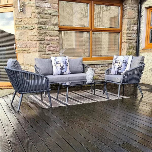 Grey 4 seater rope sofa set with cushions placed in a modern outdoor setting
