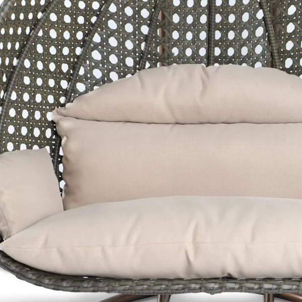 Double seater hanging swing chair with dark brown wicker frame and cream cushions