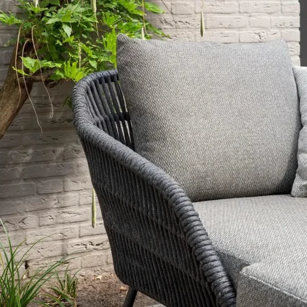Grey rope daybed set with round outdoor sofa, matching side table, and sun lounger on patio