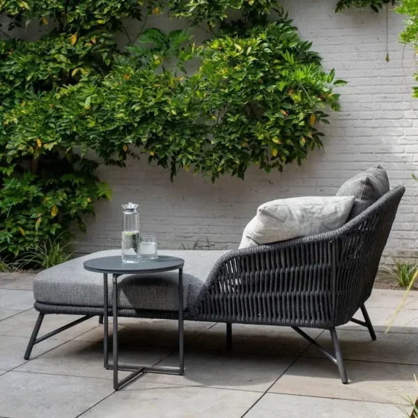 Grey rope daybed set with round outdoor sofa, matching side table, and sun lounger on patio