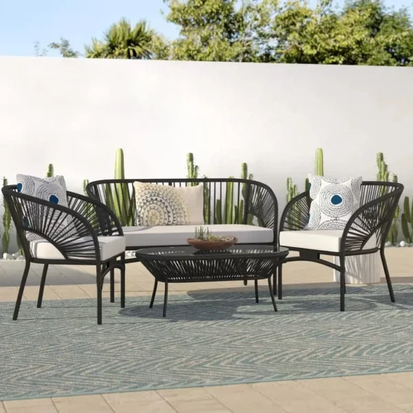 4-seater outdoor rope sofa set in black and white with a matching center table placed on a patio.