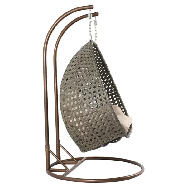 Double seater hanging swing chair with dark brown wicker frame and cream cushions