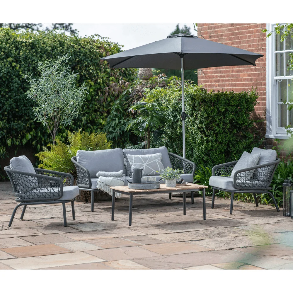 Grey 4-seater outdoor sofa set with cushions and matching table on a patio