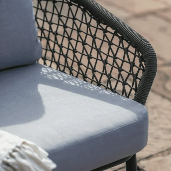 Grey 4-seater outdoor sofa set with cushions and matching table on a patio