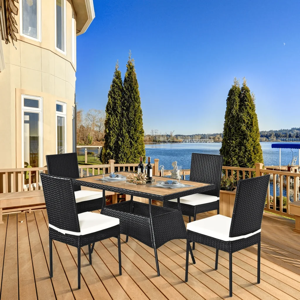 5-piece black and white rattan patio dining set with cushioned chairs and wooden tabletop