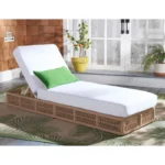 Beige rope sun lounger with a plush white cushion placed outdoors for comfortable lounging.