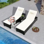 Set of 2 off-white wicker rattan outdoor chaise lounge chairs with matching side table on a patio.