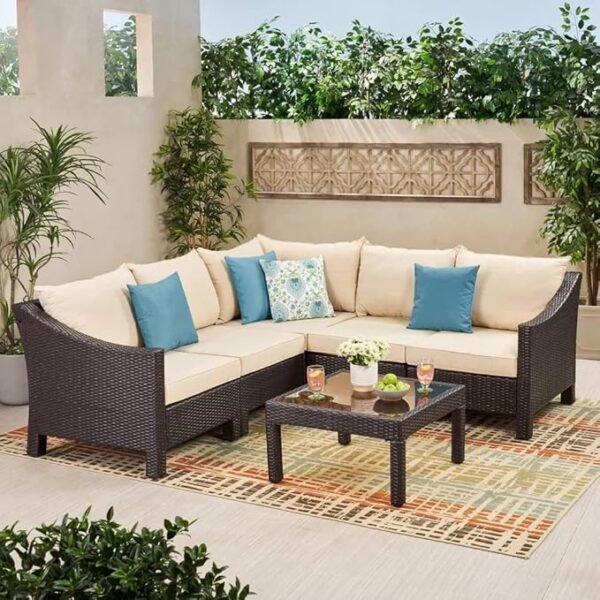 "4-piece outdoor patio furniture set with rattan sofa, cushioned chairs, and coffee table in a garden setting"