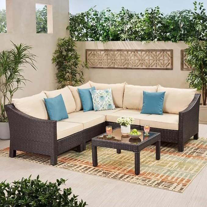 "4-piece outdoor patio furniture set with rattan sofa, cushioned chairs, and coffee table in a garden setting"
