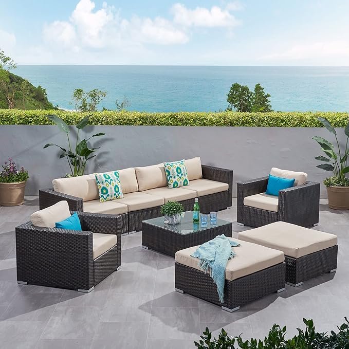 4-piece outdoor patio furniture set with rattan sofa, cushioned chairs, and coffee table in a garden setting"