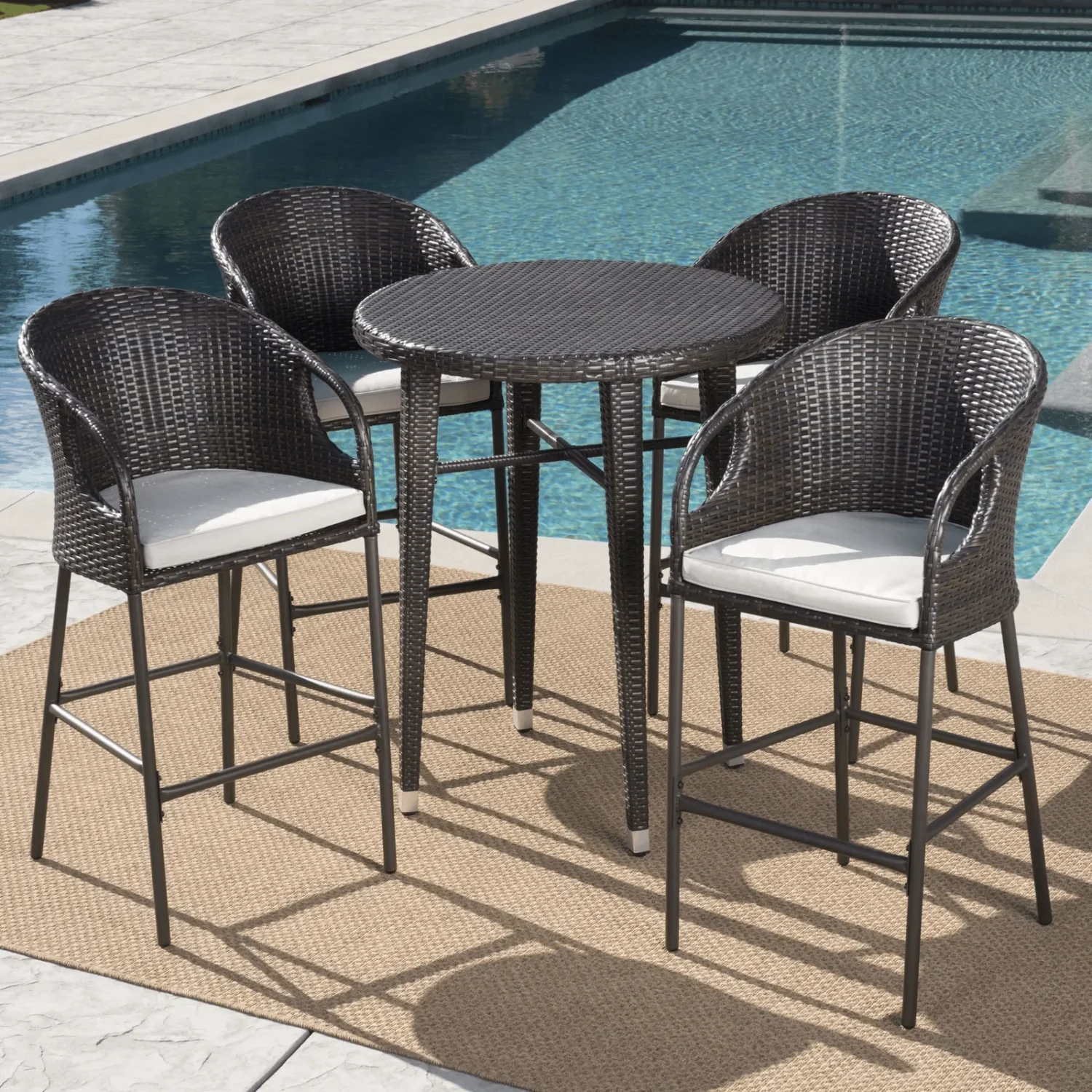 “5-piece outdoor patio bar set with rattan wicker finish, including bar table and matching stools, placed on a deck with outdoor greenery.”