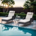 Set of 2 off-white wicker rattan outdoor chaise lounge chairs with matching table.